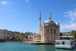 Wide-angle view of the Ortakoy Mosque with the full span of the Bosphorus Bridge stretching across the background on a clear sunny day, Istanbul.