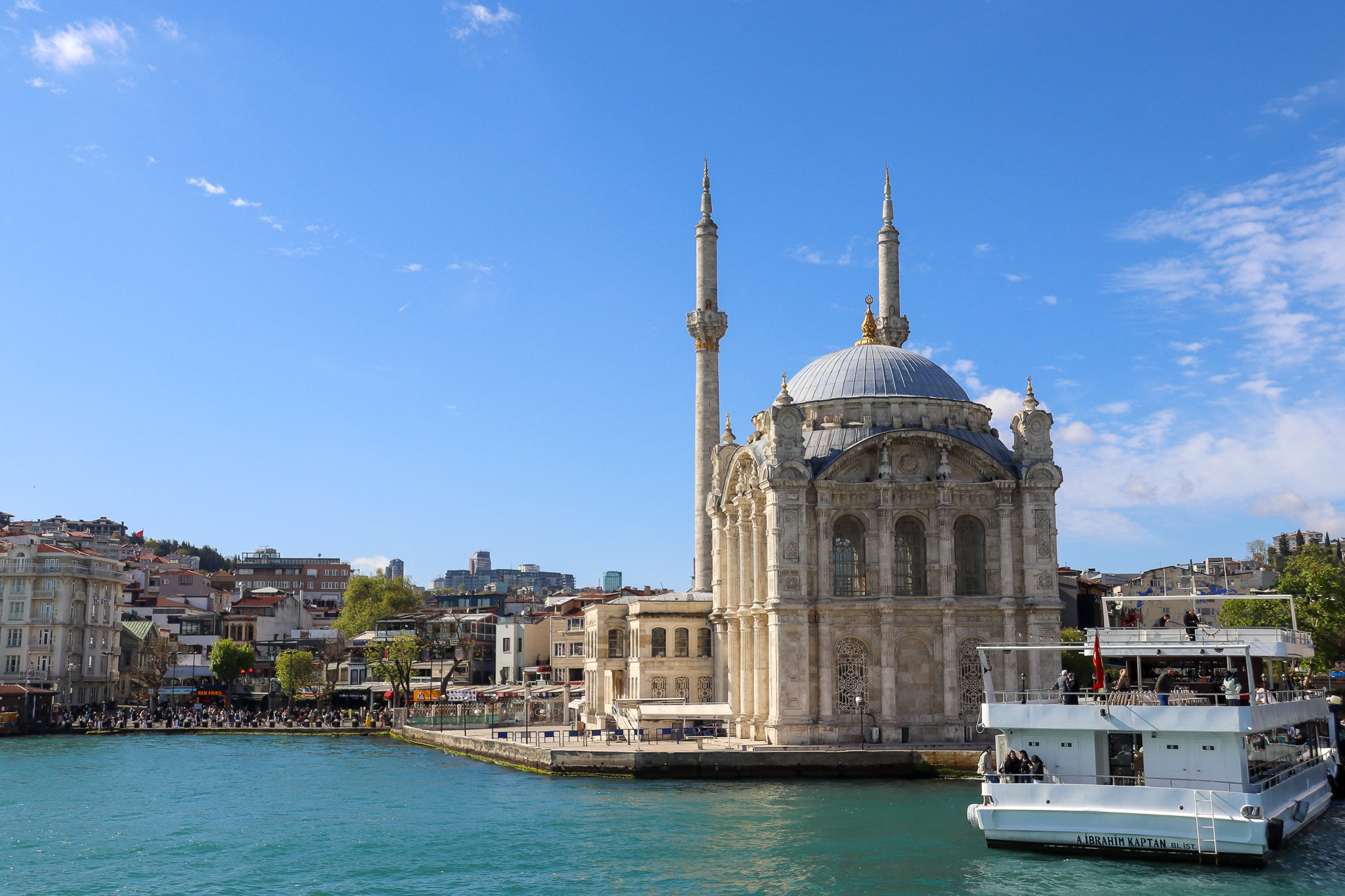 Wide-angle view of the Ortakoy Mosque with the full span of the Bosphorus Bridge stretching across the background on a clear sunny day, Istanbul.