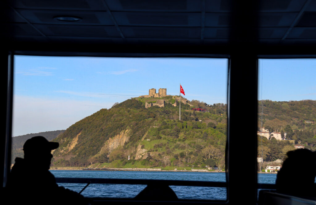 Passenger silhouette inside Bosphorus ferry looking at Asian shore, Istanbul