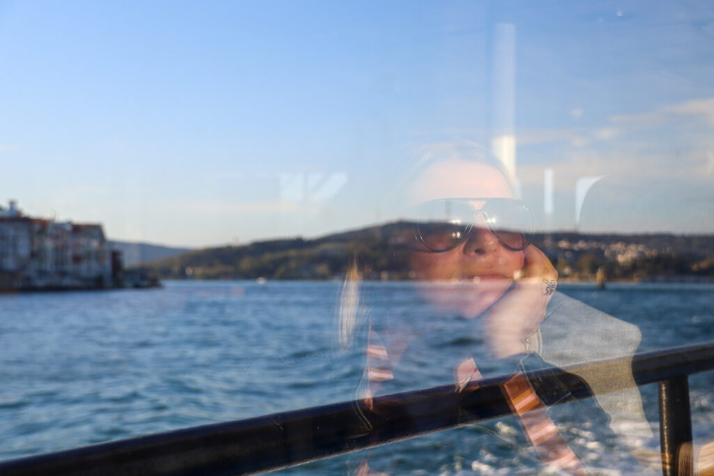 The foamy white wake of a Bosphorus ferry stretches across the glittering sunlit water as the boat heads toward Istanbul, Turkey.