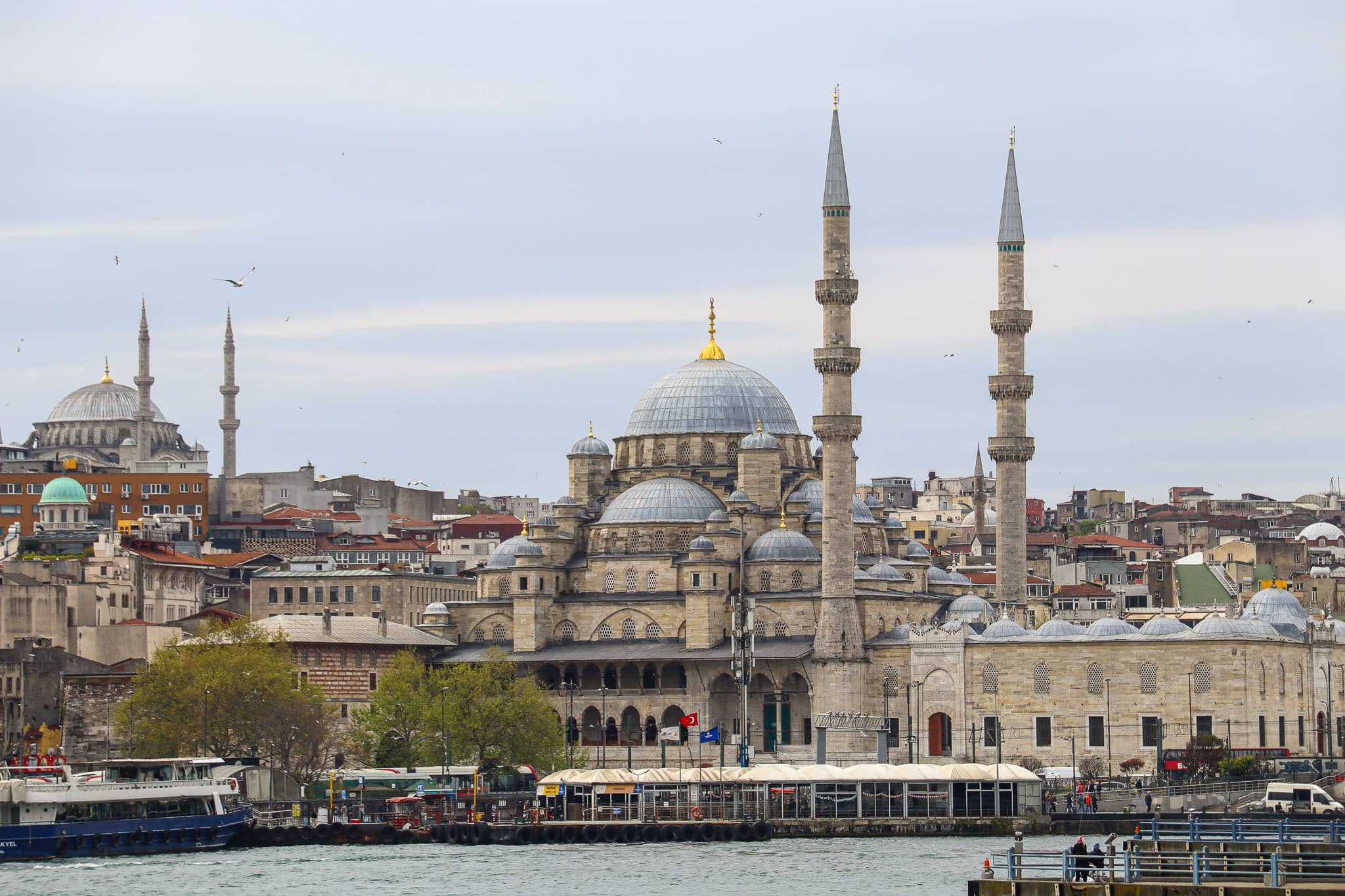 Panoramic view of the New Mosque (Yeni Cami) rising above the Istanbul rooftops with the Bosphorus visible in the background, Turkey.