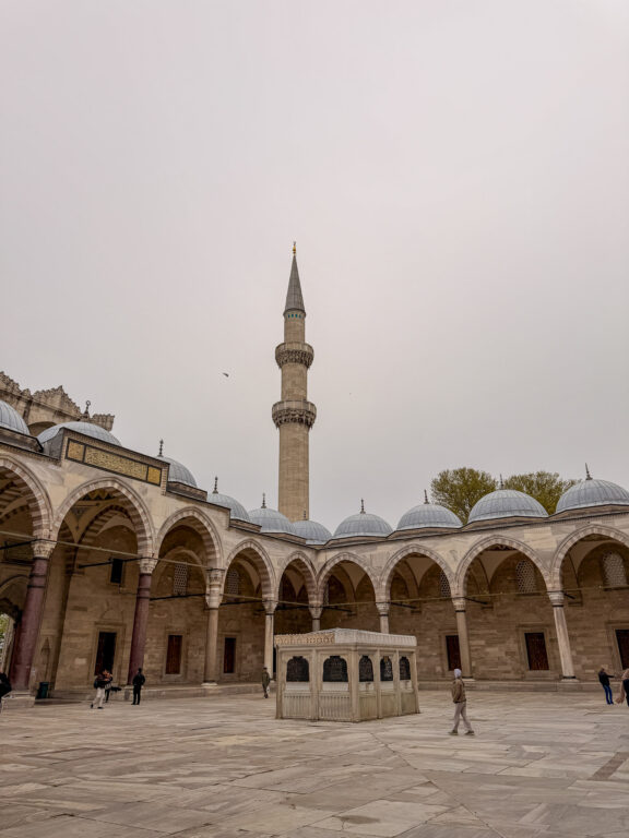 Innenhof der Süleymaniye-Moschee mit Minarett und Arkaden.