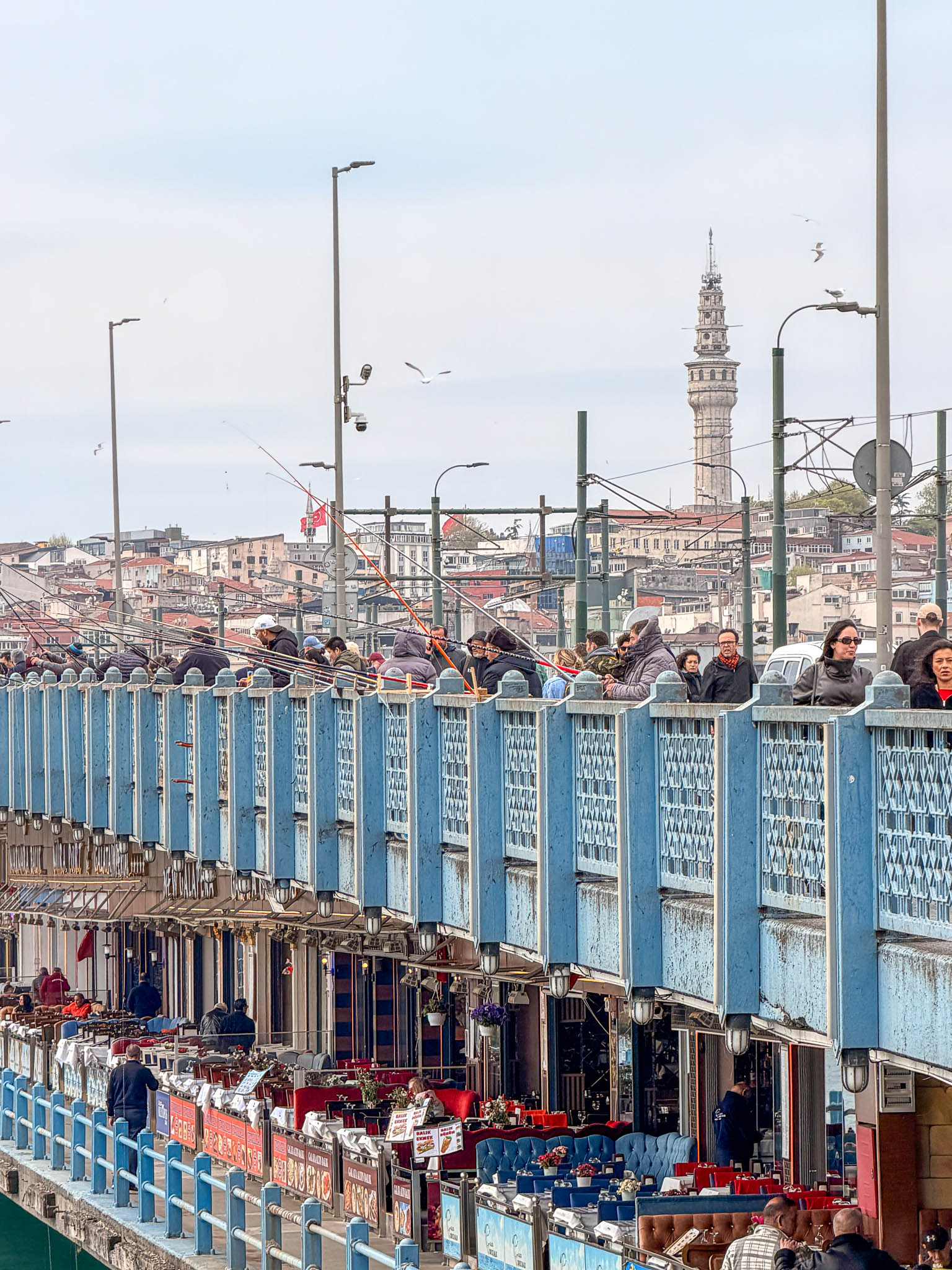 Menschen und Straßenbahn auf der Galatabrücke mit Blick auf Istanbul.